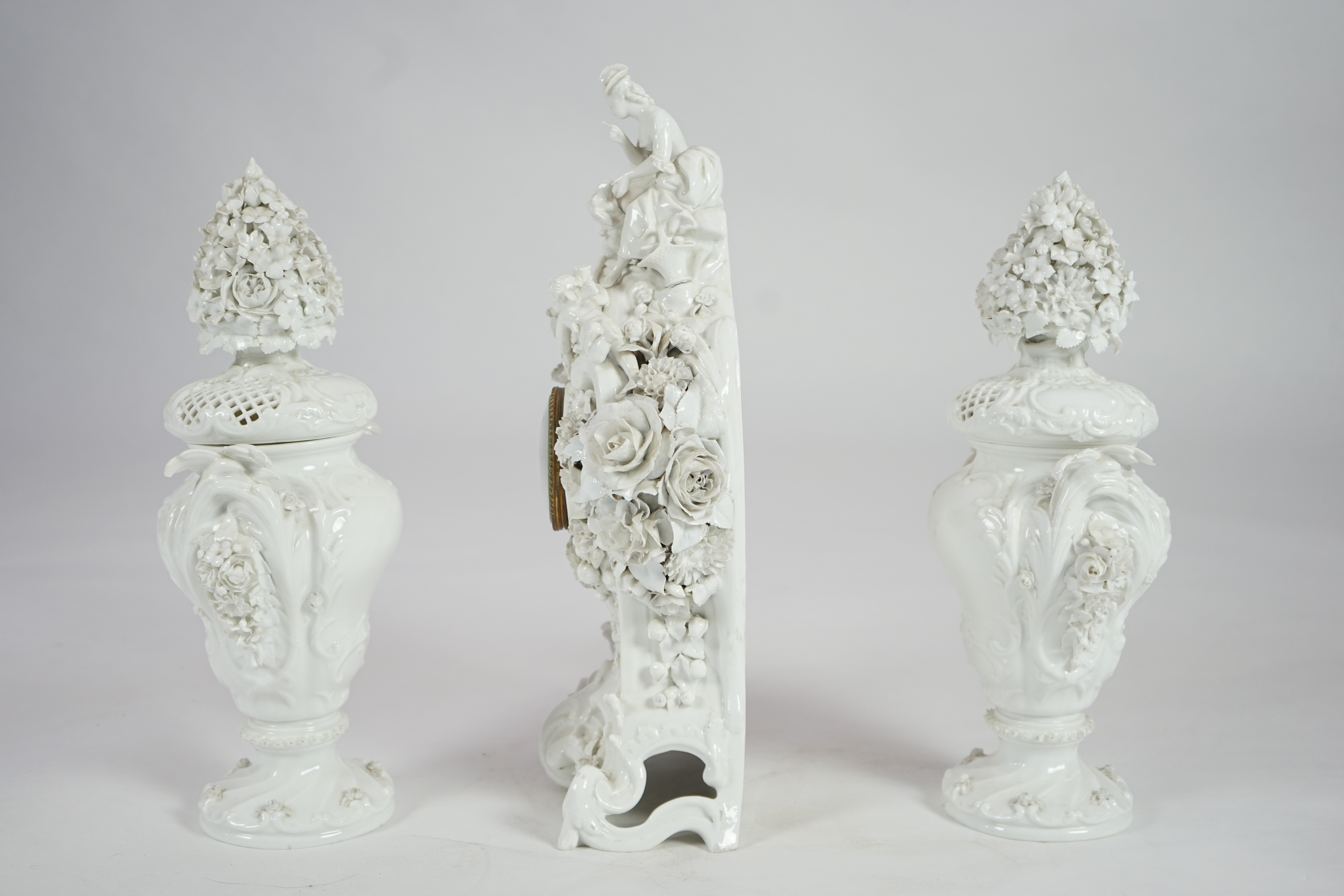 Vion & Baury. A 19th century Meissen style white glazed porcelain three piece clock set